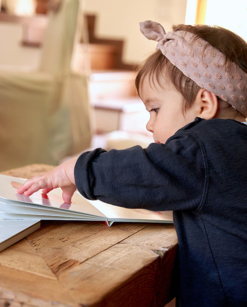 bambina sfoglia libro per la prima infanzia di slegato