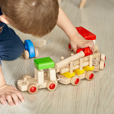 bambino che gioca con trenino in legno ecosostenibile di slegato